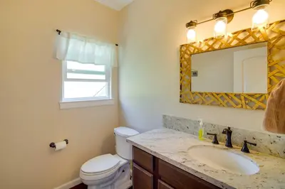 a bathroom with a sink and a toilet and a mirror at Lake Arrowhead Getaway with Decks and Game Room! in Lake Arrowhead