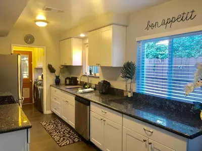 a kitchen with white cabinets and a large window at Endless summer in LA *HEATED POOL/HOT TUB/CABANA* in Los Angeles