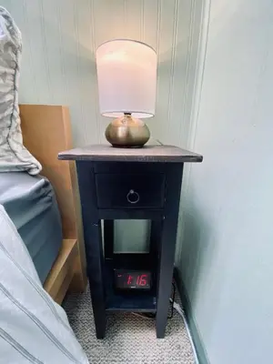 a nightstand with a lamp on it next to a bed at Snow Bunny Cottage, Pets Welcomed! in Green Valley Lake