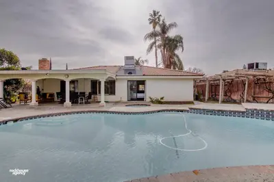 a large swimming pool in front of a house at Cozy Hygge Home Centrally Located 2 King Beds in Bakersfield