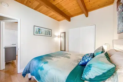a bedroom with a large bed with blue pillows at Timber Top Retreat in Lake Arrowhead
