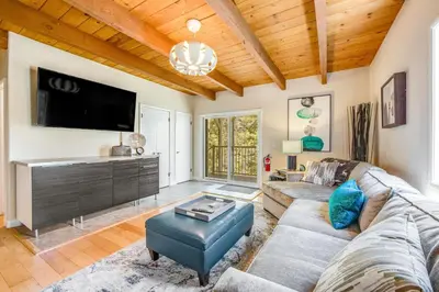 a living room with a couch and a flat screen tv at Timber Top Retreat in Lake Arrowhead