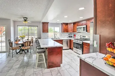 a kitchen with wooden cabinets and a table with fruits on it at Bright California Home with Patio Less Than 1 Mi to Hiking! in Corona