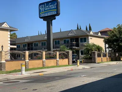a sign for a hotel on the side of a street at Walnut Inn & Suites West Covina in West Covina