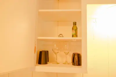 two wine glasses sitting on a shelf in a kitchen at Sherwood Arms Motel in Running Springs