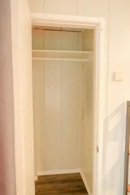 a walk in closet with white walls and wood floors at Sherwood Arms Motel in Running Springs