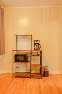 a microwave on a shelf in a room at Sherwood Arms Motel in Running Springs