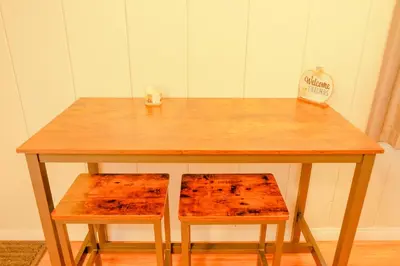 a wooden table with two chairs and a sign at Sherwood Arms Motel in Running Springs