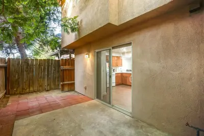 a patio with a sliding glass door leading to a kitchen at Convenient Bakersfield Townhome with Patio! in Bakersfield