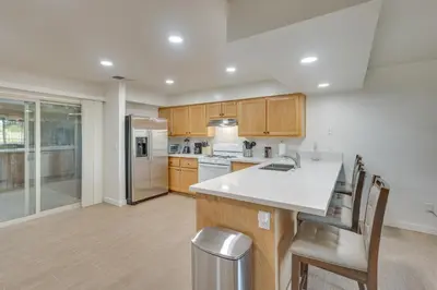 a kitchen with wooden cabinets and a white counter top at Convenient Bakersfield Townhome with Patio! in Bakersfield