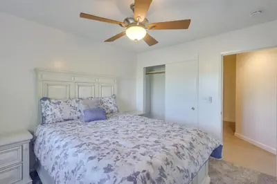 a bedroom with a bed with a ceiling fan at Convenient Bakersfield Townhome with Patio! in Bakersfield