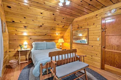 a bedroom with a bed and a chair in a log cabin at Big Bear Lake Cabin about 4 Mi Snow Summit Ski Resort in Big Bear Lake