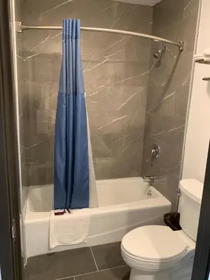 a bathroom with a toilet and a shower curtain at Desert Inn Motel in Corona