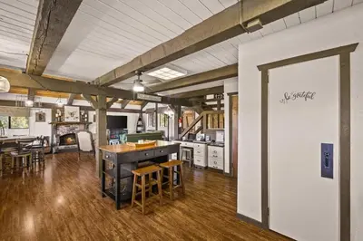 a kitchen and living room with a table and chairs at The Lake Chalet in Crestline