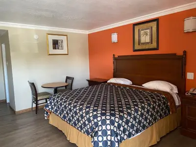 a hotel room with a bed and a table at Downtown Motel 7 in San Bernardino