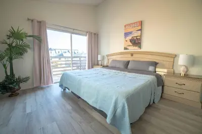 a bedroom with a bed and a large window at Ocean View / Pool Table / Surfboards / Beach Bikes in Oxnard