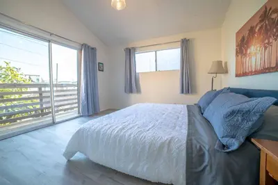a bedroom with a bed and a large window at Ocean View / Pool Table / Surfboards / Beach Bikes in Oxnard
