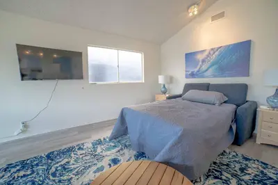 a bedroom with a bed and a couch and a window at Ocean View / Pool Table / Surfboards / Beach Bikes in Oxnard