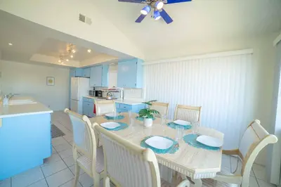 a dining room with a table and chairs and a kitchen at Ocean View / Pool Table / Surfboards / Beach Bikes in Oxnard