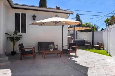 a patio with a table and an umbrella at Adorable 3 bedroom with Jacuzzi & more in Los Angeles