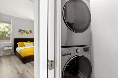 a room with a washing machine and a bedroom at Adorable 3 bedroom with Jacuzzi & more in Los Angeles