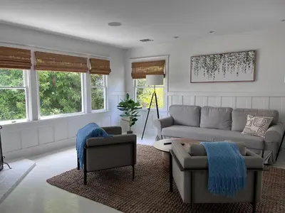 a living room with a couch and chairs and windows at The Craftsman House in Venice Beach in Los Angeles