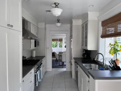 a kitchen with white cabinets and black counter tops at The Craftsman House in Venice Beach in Los Angeles