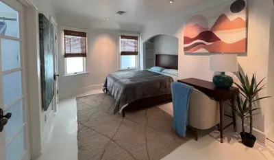 a bedroom with a bed and a painting on the wall at The Craftsman House in Venice Beach in Los Angeles