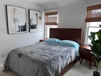 a bedroom with a bed with blue pillows on it at The Craftsman House in Venice Beach in Los Angeles