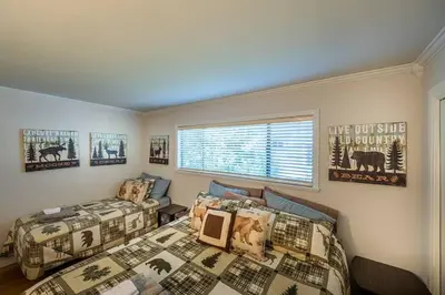 a bedroom with two beds and a window at TheDragon's Den Mega Cabin Sleeps 12 in Lake Arrowhead