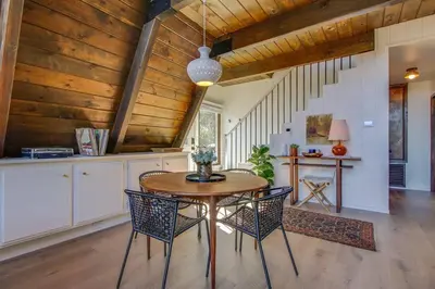 a kitchen with a wooden ceiling and a wooden table and chairs at Roots Mountain House Modern A-Frame in Lake Arrowhead