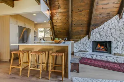 a kitchen with a fireplace in a house at Roots Mountain House Modern A-Frame in Lake Arrowhead