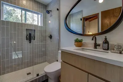 a bathroom with a toilet and a sink and a mirror at Roots Mountain House Modern A-Frame in Lake Arrowhead