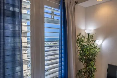 a room with a window with blinds and a plant at 2 Bed Ocean View Balconys Corner Unit LB Convention Center in Long Beach