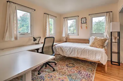 a bedroom with a bed and a desk and windows at Charming Santa Paula Home - Walk to Downtown! in Santa Paula
