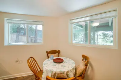 a dining room with a table and chairs and two windows at Cozy Crestline Getaway about 2 Mi to Lake Gregory in Crestline