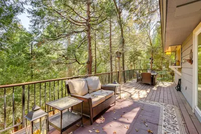 a porch with a chair and a table and trees at Spacious Retreat 13 Mi to Snow Valley Mtn Resort! in Lake Arrowhead