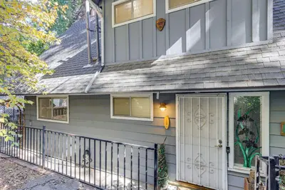 a house with a porch and a white door at Spacious Retreat 13 Mi to Snow Valley Mtn Resort! in Lake Arrowhead