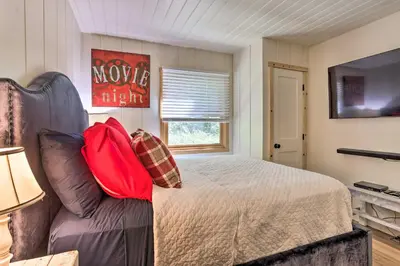 a bedroom with a bed and a couch and a television at Steps to Lake Cabin with Deck in Lake Arrowhead in Lake Arrowhead