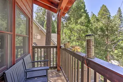 a porch with two chairs and a heater at Steps to Lake Cabin with Deck in Lake Arrowhead in Lake Arrowhead