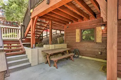 a wooden cabin with a picnic table and stairs at Steps to Lake Cabin with Deck in Lake Arrowhead in Lake Arrowhead