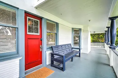 a bench on a porch with a red door at Cozy Carpinteria Apartment Walkable Location in Carpinteria
