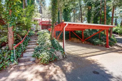 a set of stairs with a red structure in a forest at Top Town Retreat in Crestline