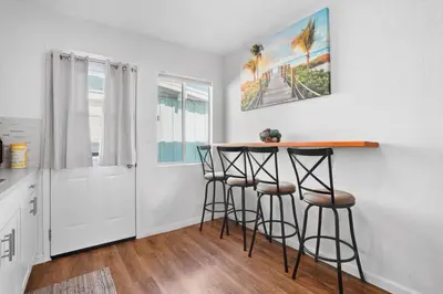 a kitchen with a bar with stools in a room at The Green Haven, 1 Minute Walk to the Beach and Restaurants, King Beds, Beach Amenities in Ventura