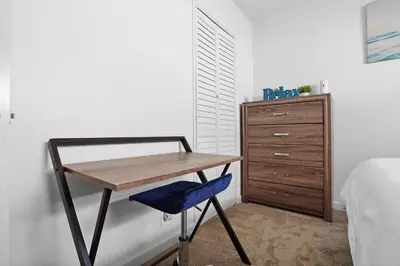 a desk in a bedroom with a bed and a dresser at The Green Haven, 1 Minute Walk to the Beach and Restaurants, King Beds, Beach Amenities in Ventura