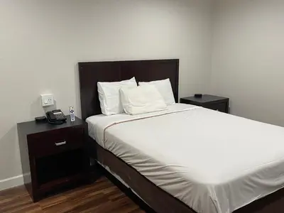 a bedroom with a bed and a phone on a table at Lanai Motel in Alhambra