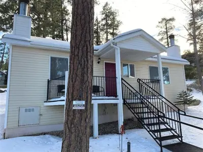 a house with a staircase in front of a tree at Cozy Lake-View Lodge Near Village in Big Bear Lake