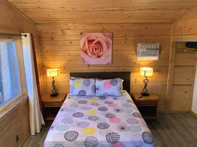 a bedroom with a bed with a pink rose on the wall at Cozy Lake-View Lodge Near Village in Big Bear Lake