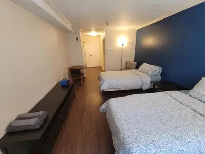 a room with two beds and a blue wall at (A11) Lovely Double Bed Unit in Los Angeles