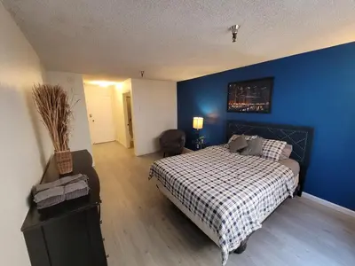 a bedroom with a bed and a blue wall at (A13) Cozy 1 Bedroom Studio with Private Bath in Los Angeles